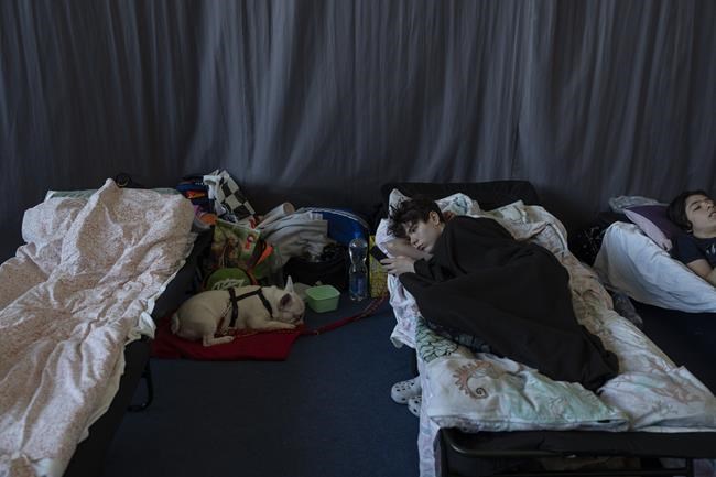 People who fled the war in Ukraine rest inside an indoor sports stadium of a high school in Przemysl, southeastern Poland, on Friday March 18, 2022. (AP Photo/Petros Giannakouris)