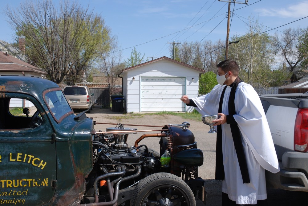 Kimberley Kielly/The Brandon Sun
Pastor Jonathon Hoskin of St. George's Anglican Church in Brandon blesses a 1938 International truck on Sunday during the 