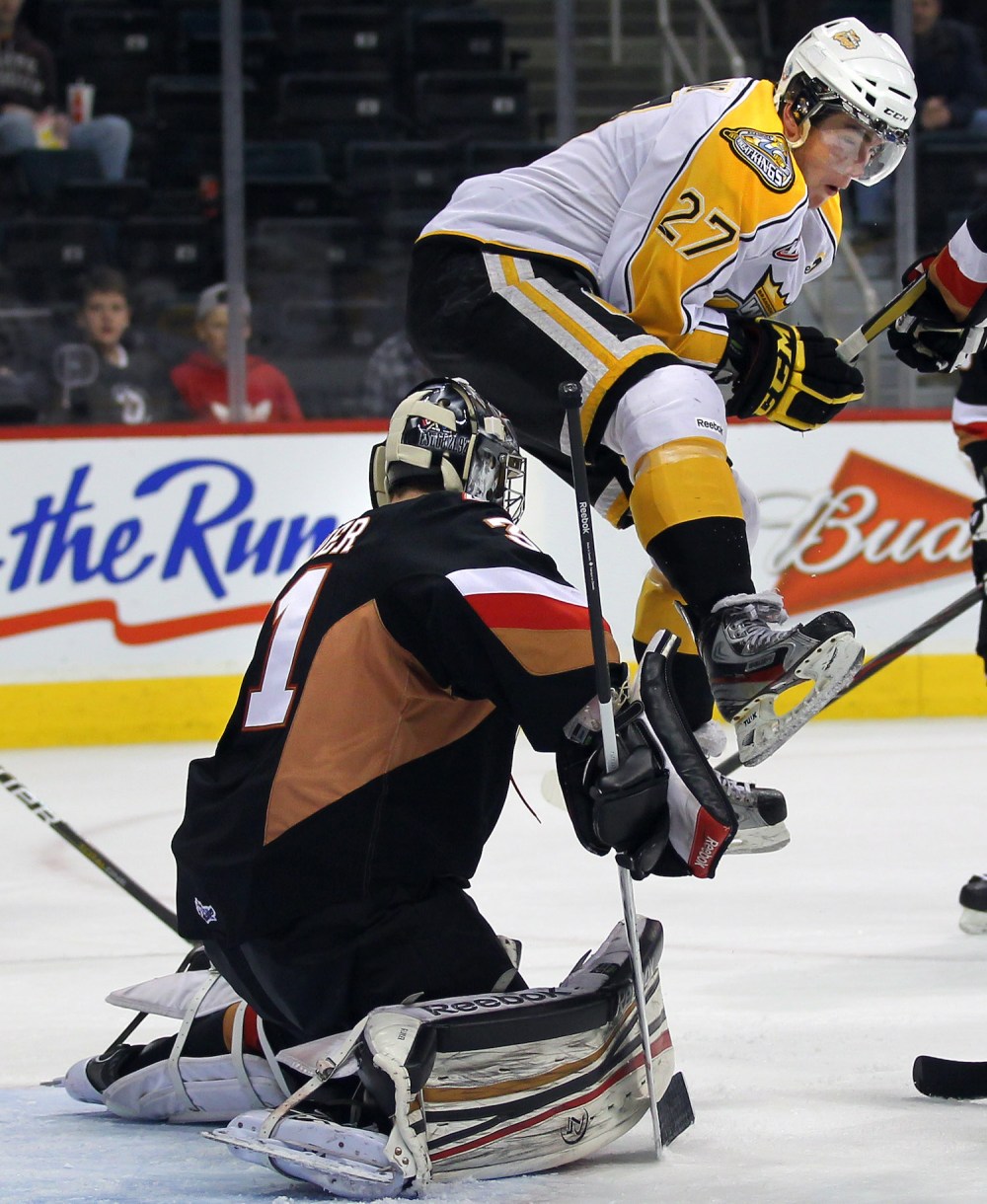 Phil Hossack/Winnipeg Free Press
Brandon Wheat King's Michael Ferland leaps in front of Calgary Hitmen's netminder Brandon Glover in playoff action at the MTS Centre in Winnipeg on March 29, 2012.