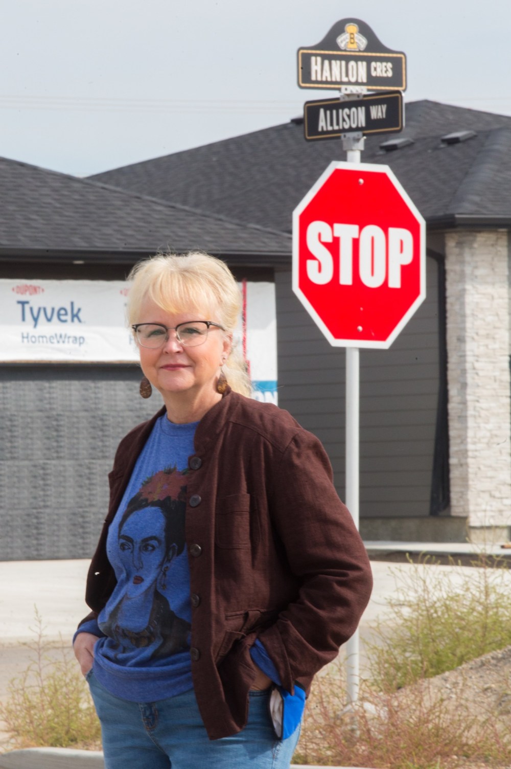 Chelsea Kemp/The Brandon Sun
Coun. Jan Chaboyer (Green Acres) stands next to street signs named after hockey players in a new development Friday.