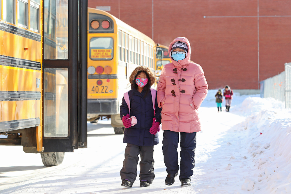 School busses wait to transport students home at École New Era School on a frigid afternoon back in February of this year. On Monday, a Brandon School Division official confirmed that an outbreak had been declared at École New Era School, with the spread impacting a Grade 4/5 classroom. (File)
