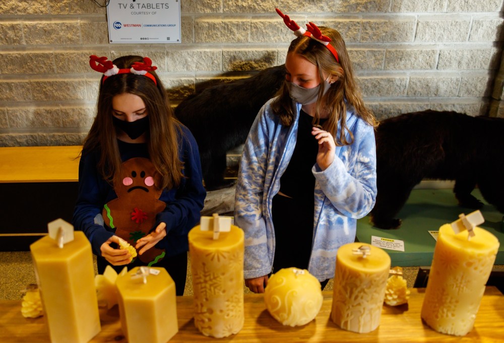 Chelsea Kemp/The Brandon Sun
Tayden Riddle, 12, left, and Elizabeth Graham, 14, browse the Prairie Sun Beeswax booth during the sale on Saturday.