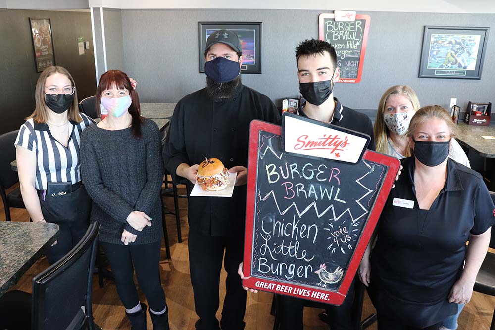 Kyle Darbyson/The Brandon Sun
The staff of Smitty's in Brandon pose for a group photo with their Chicken Little Burger on Friday afternoon. The signature burger helped the restaurant win the 2021 Burger Brawl competition.