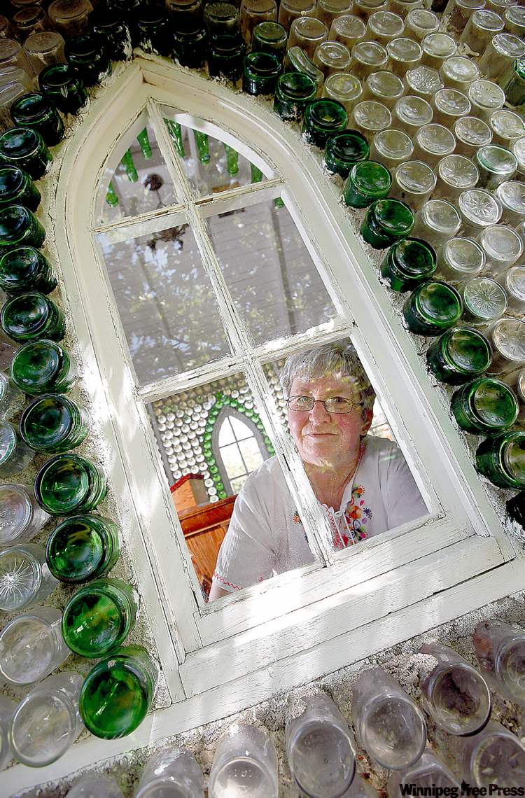 PHIL.HOSSACK@FREEPRESS.MB.CA
Treherne community development officer Pat Sparling looks out window of church built of bottles.
