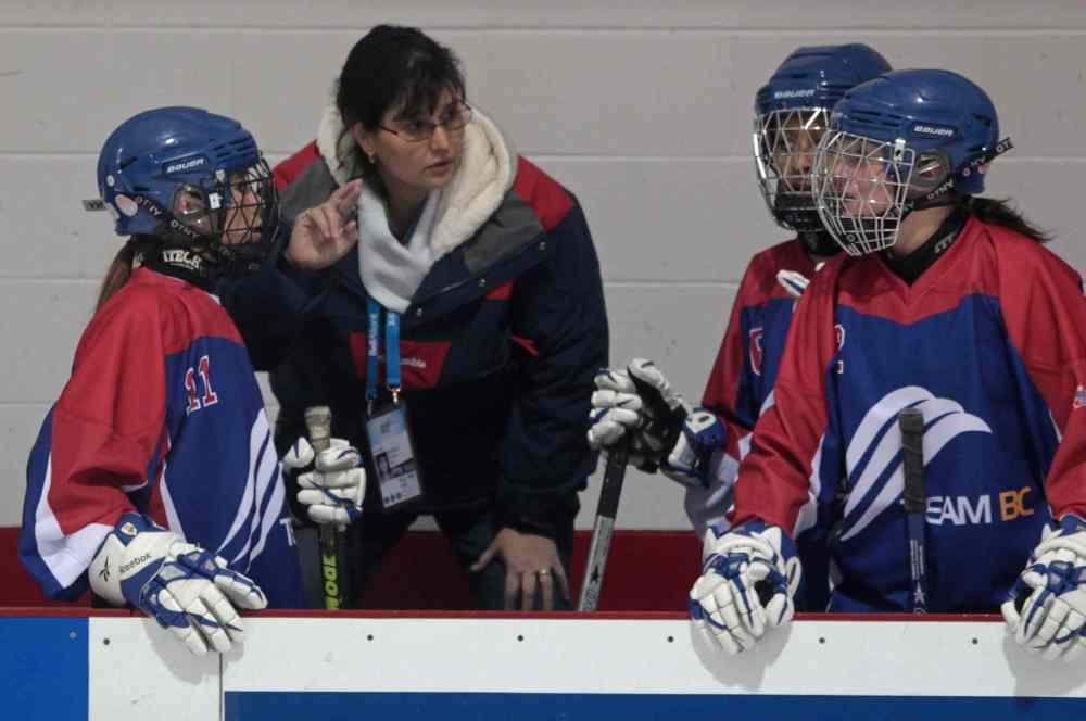 Mike Dembeck / THE CANADIAN PRESS Archives
Elizabeth Dagg (left), a deaf ringette player, watches as her mother, Nora, relays her teammate's speech in sign language at the 2011 Canada Winter Games. Manitoba's Sport Secretariat has agreed to pay up to $40,000 per year so deaf children can communicate with coaches and game officials.