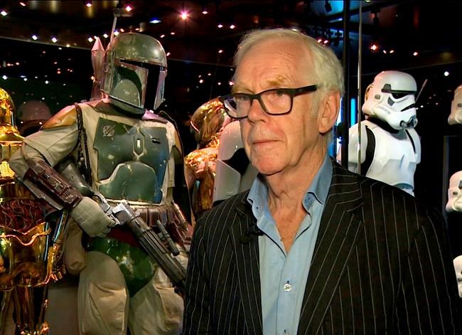 Jeremy Bulloch speaks in front of the costume he wore while playing Boba Fett in