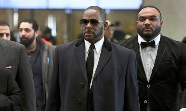 FILE - In this May 7, 2019 file photo, Musician R. Kelly, center, arrives at the Leighton Criminal Court building for a hearing in Chicago. Prosecutors charged R&B singer R. Kelly on Thursday, May 30, with 11 new sex-related counts, including some that carry a maximum sentence of 30 years in prison, making them the most serious against him. (AP Photo/Matt Marton, File)