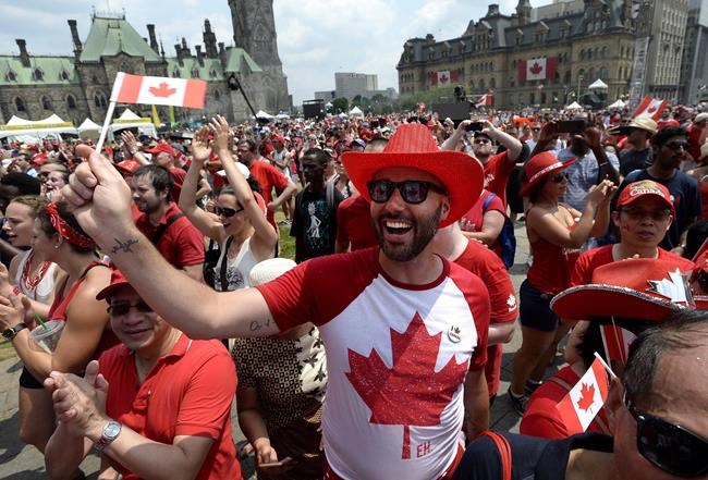 People cheer during Canada Day celebrations on Parliament Hill in Ottawa on Sunday, July 1, 2018. Canada's biggest annual birthday bash is being shifted away from Parliament Hill. THE CANADIAN PRESS/Justin Tang