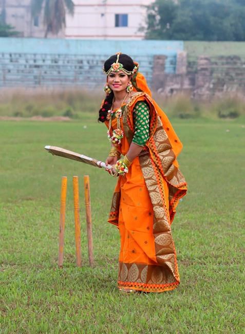 Bangladeshi cricketer Sanjida Islam poses as a bride with a cricket bat, a day before her wedding day in Rangpur, Bangladesh, Friday, Oct. 16. (Sobhana Mostary via AP)