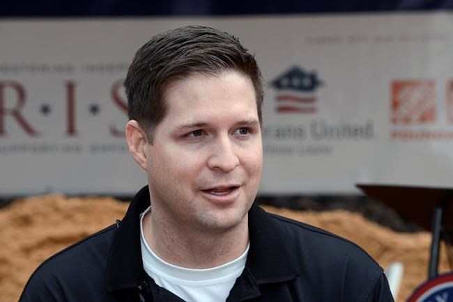 FILE - In this Jan. 14, 2016 photo, retired U.S. Air Force Sr. Airman Brian Kolfage speaks to the media during a groundbreaking ceremony for a new home he and his family were receiving through the Gary Sinise Foundation's RISE program at Sandestin, Fla. Former White House adviser Steve Bannon was arrested Thursday, Aug. 20, 2020, on charges that he and three others, including Kolfage, ripped off donors to an online fundraising scheme “We Build The Wall.” (Devon Ravine/Northwest Florida Daily News via AP, File)