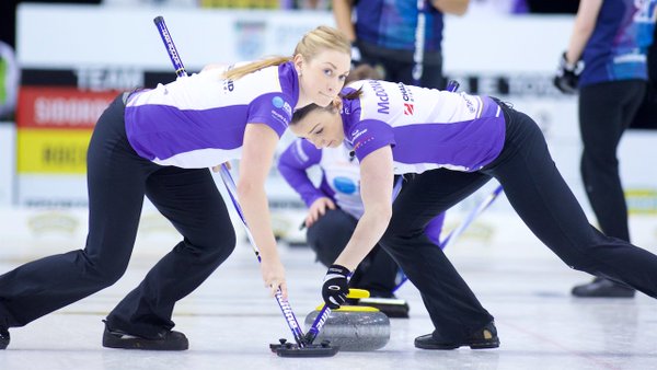 Jen Gates, left, seen sweeping a stone at a recent Grand Slam of Curling event is still close with older sister Amanda despite moving across the country.
