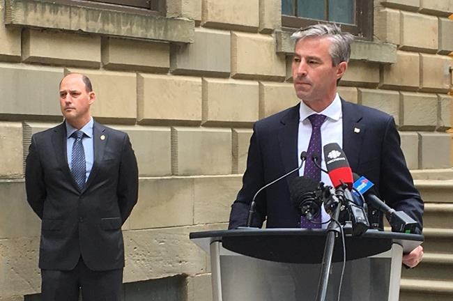 Nova Scotia Progressive Conservative Leader Tim Houston takes questions from reporters, Wednesday, June 24, 2020 outside the provincial legislature in Halifax as party education critic Tim Halman looks on. Nova Scotia's Progressive Conservatives are calling on the province's Liberal government to release its plan for the return of students to public schools this fall.THE CANADIAN PRESS/Keith Doucette.