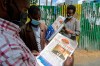 Ethiopians read newspapers and magazines reporting on the current military confrontation in the country, one of which shows a photograph of Prime Minister Abiy Ahmed, on a street in the capital Addis Ababa, Ethiopia Saturday, Nov. 7, 2020. Ethiopia moved Saturday to replace the leadership of the country's defiant northern Tigray region, where deadly clashes between regional and federal government forces are fueling fears the major African power is sliding into civil war. (AP Photo/Samuel Habtab)