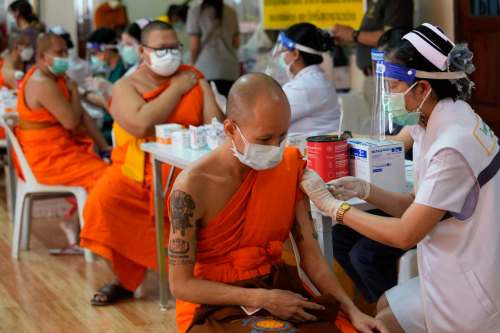 Health workers administer doses of the AstraZeneca COVID-19 vaccine to Buddhist monks at the Wat Srisudaram in Bangkok, Thailand, on Friday. (The Associated Press)