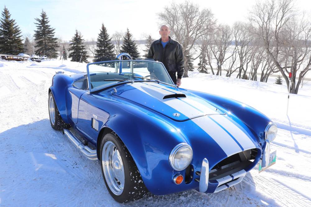 Kyle Darbyson/The Brandon Sun
Gord Chester poses for a photo with his replica Shelby Cobra outside his home on Thursday morning. Chester told the Sun that he had ambitions of owning a Cobra since his youth and opted to build his own with a roadster kit due to the rarity of this famous British sports car.