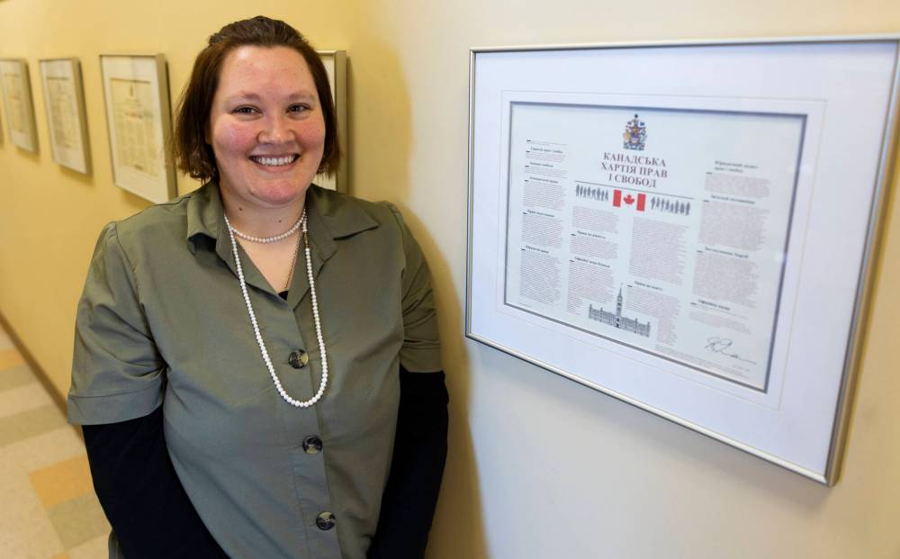 Chelsea Kemp/The Brandon Sun
Westman Immigrant Services community outreach manager Hannah Holt stands in front of the Canadian Charter of Rights and Freedoms Friday.