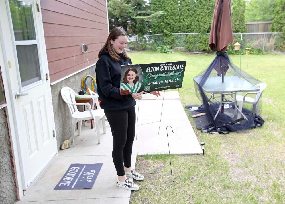 Elton Collegiate graduate Jocelyn Terhoch smiles after being presented with a custom graduation lawn sign by principal Mark Geekie at her home in Brandon on Thursday. (Tim Smith/The Brandon Sun)