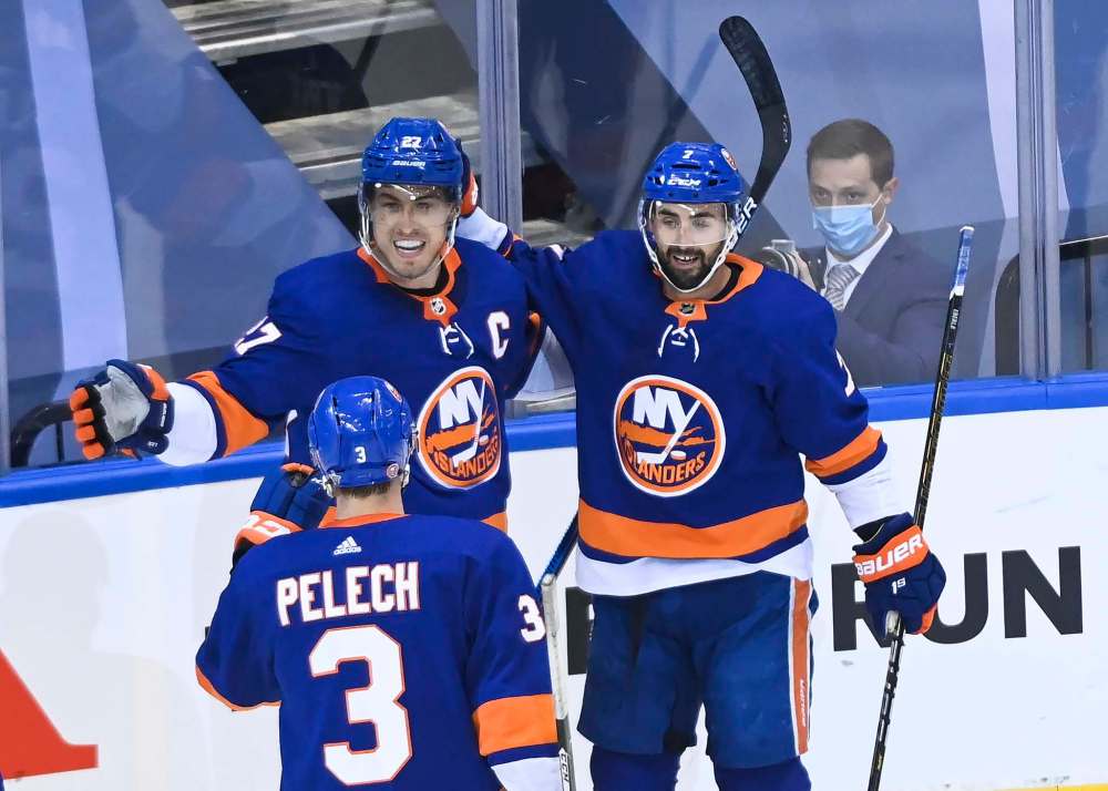 New York Islanders left wing Anders Lee, left, celebrates his goal with teammates Adam Pelech, right, and Jordan Eberle while playing against the Washington Capitals during first period NHL Eastern Conference Stanley Cup playoff hockey action in Toronto on Aug. 16.(The Canadian Press)