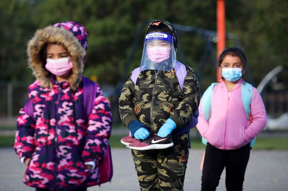 Brandon Sun 08092020
Students wearing masks wait in lines based on their grade and class before the start of their first school day at Meadows School in Brandon on Tuesday morning. Meadows opened at 50% capacity on Tuesday with half of students attending. The other half will have their first day of school Wednesday. (Tim Smith/The Brandon Sun)