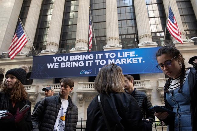 FILE - In this Monday, March 9, 2020 file photo, people stop to look at the New York Stock Exchange. Stocks are opening sharply lower on Wall Street Wednesday as fears of economic fallout from the coronavirus outbreak grip markets again. (AP Photo/Mark Lennihan, File)