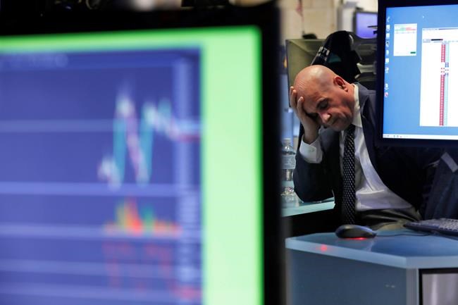A specialist rests his head in his hand as he works on the floor of the New York Stock Exchange, Tuesday, Feb. 25, 2020. U.S. stocks fell in midday trading Tuesday, a day after the market's biggest drop in two years, as traders worry that the spreading coronavirus will threaten global economic growth. (AP Photo/Richard Drew)