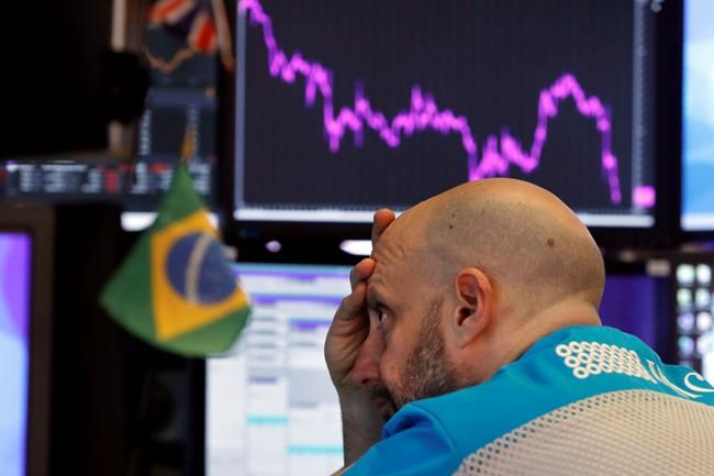 Specialist Meric Greenbaum works at his post on the floor of the New York Stock Exchange, Tuesday, Feb. 25, 2020. Stocks slumped and bond prices soared for the second day in a row as fears spread that the widening virus outbreak will put the brakes on the global economy. (AP Photo/Richard Drew)