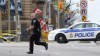An Ottawa police officer runs with his weapon drawn in Ottawa on Wednesday Oct.22, 2014.Police are expanding a security perimeter in the heart of the national capital after a gunman opened fire and wounded a soldier at the National War Memorial before injuring a security guard on Parliament Hill, where he was reportedly shot dead by Parliament's sergeant-at-arms. THE CANADIAN PRESS/Sean Kilpatrick