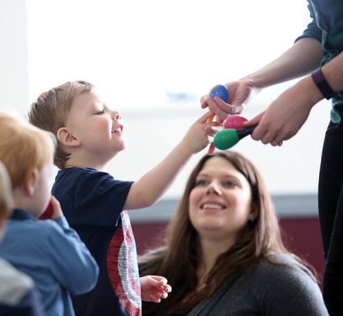 Twenty-one-month old Rider Gray and eight other kids give their shakers back to music therapist Courtney Kjaldgaard near the end of their class at Knox United Church. (Michael Lee/The Brandon Sun)