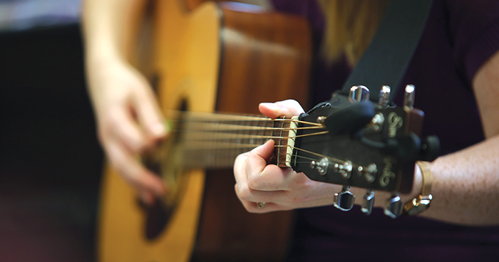 Courtney Kjaldgaard strums a chord during her music therapy class at Family Visions. (Michael Lee/The Brandon Sun)