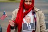 Tina Puente wears a portrait of President Donald Trump as she gathers with other supporters in anticipation of his visit to the U.S.-Mexico border, Tuesday, Jan. 12, 2021, in Harlingen, Texas. (AP Photo/Eric Gay)