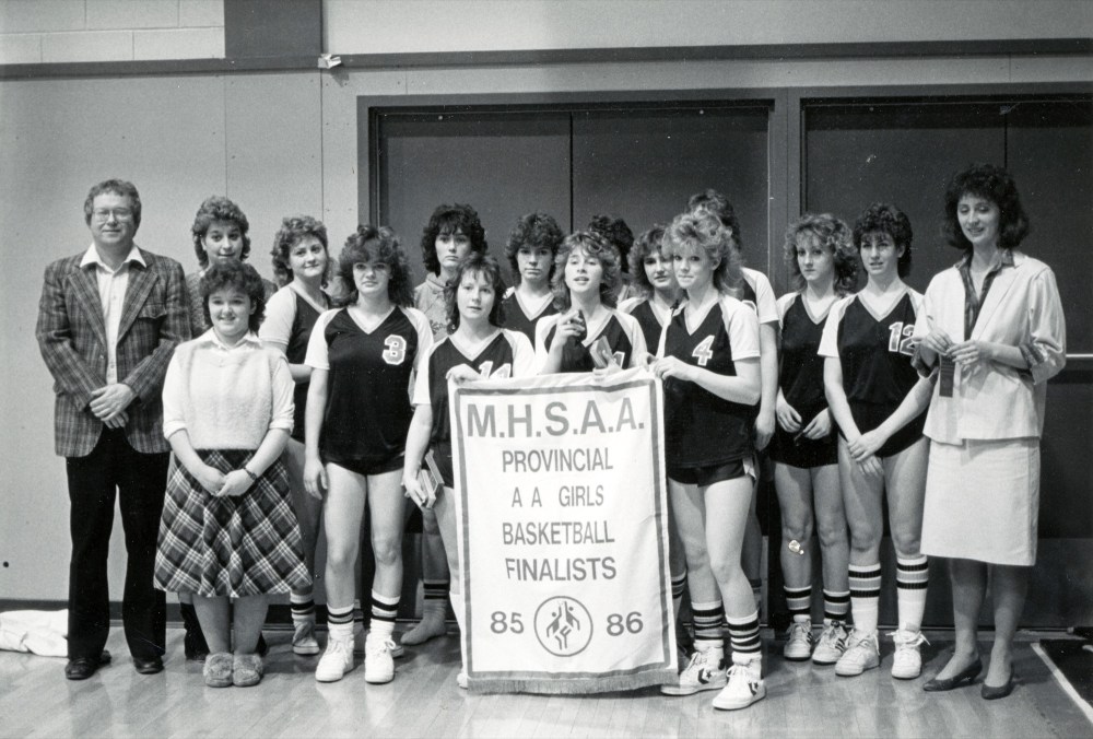 Submitted
Ray Hurd, left, and the Killarney Raiders pose with their 1986 varsity girls AA provincial basketball finalists banner. Four years after Hurd won gold, he moved on from Killarney.