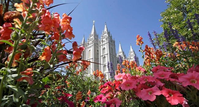 FILE - This Aug. 4, 2015 file photo, flowers bloom in front of the Salt Lake Temple, at Temple Square, in Salt Lake City. The Church of Jesus Christ of Latter-day Saints is reminding members that coffee is prohibited no matter how fancy the name, that vaping is banned despite the alluring flavors and that marijuana is outlawed unless prescribed by a competent doctor. (AP Photo/Rick Bowmer, File)