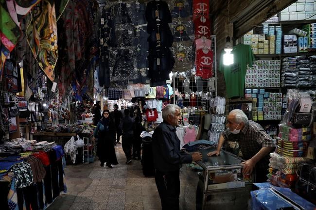 People conduct their business at the Qazvin old traditional bazaar some 93 miles (150 kilometers) northwest of the capital Tehran Iran, Wednesday, April 22, 2020. Iran's Revolutionary Guard said it put the Islamic Republic's first military satellite into orbit, dramatically unveiling what experts described as a secret space program with a surprise launch Wednesday that came amid wider tensions with the United States. (AP Photo/Vahid Salemi)