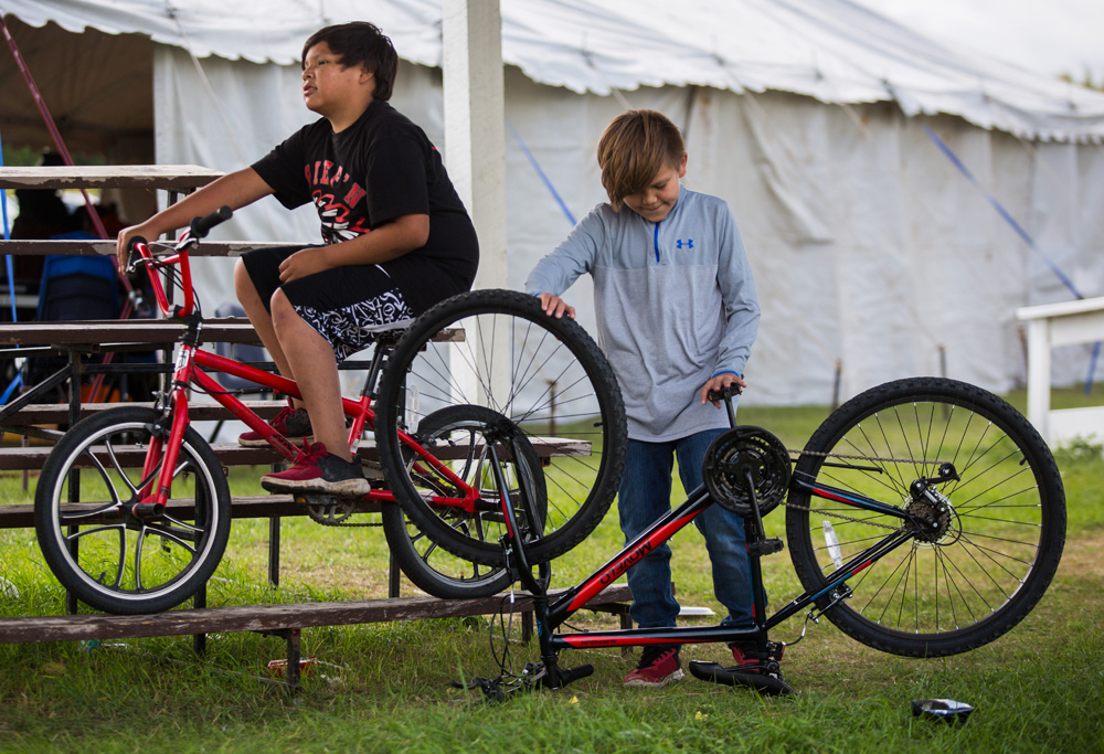 Ethan Tacan, 11, left, and TJ Wasteste, 10, get ready to race their bikes at the Dakota Tiwahe Services and Jordan's Principal hosted Sioux Valley Culture Camp on Aug. 27.  (Chelsea Kemp/The Brandon Sun)