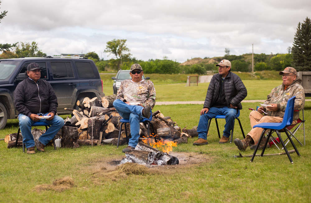 Harold Blacksmith, second from right, helps tend the fire at the Dakota Tiwahe Services and Jordan's Principal hosted Sioux Valley Dakota Nation Culture Camp on Aug. 27.  (Chelsea Kemp/The Brandon Sun)