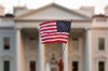 FILE - In this Sept. 2017 file photo, a flag is waved outside the White House, in Washington. The Trump administration announced Friday that it was curbing legal immigration from six additional countries that officials said did not meet security screening standards, as part of an election-year push to further restrict immigration. Officials said immigrants from Kyrgyzstan, Myanmar, Eritrea, Nigeria, Sudan and Tanzania will face new restrictions in obtaining certain visas to come to the United States. But it is not a total travel ban, unlike President Donald Trump‚Äôs earlier effort that generated outrage around the world for unfairly targeting Muslims. (AP Photo/Carolyn Kaster)