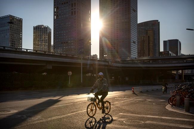 A man wears a face mask as he rides a bicycle along a mostly empty street in Beijing, Saturday, Feb. 22, 2020. South Korea on Saturday reported an eight-fold jump in viral infections in four days to 433, most of them linked to a church and a hospital in and around the country's fourth-largest city, where health workers scrambled to screen thousands of worshipers. (AP Photo/Mark Schiefelbein)