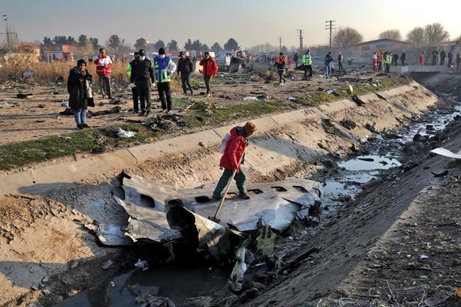 Rescue workers inspect the scene where a Ukrainian plane crashed in Shahedshahr, southwest of the capital Tehran, Iran, Wednesday, Jan. 8, 2020. A Ukrainian airplane with more than 170 people crashed on Wednesday shortly after takeoff from Tehran's main airport, killing all onboard. (AP Photo/Ebrahim Noroozi)