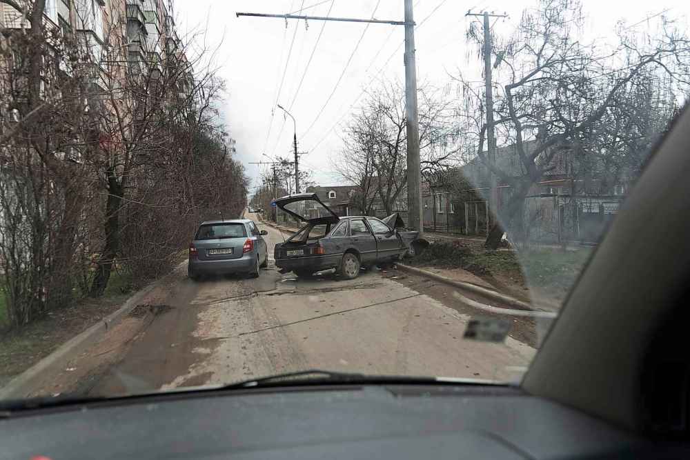 A car escaping from shelling drives past a crashed vehicle in Mariupol, Ukraine, Friday, March 4, 2022 (Mstyslav Chernov / The Associated Press)