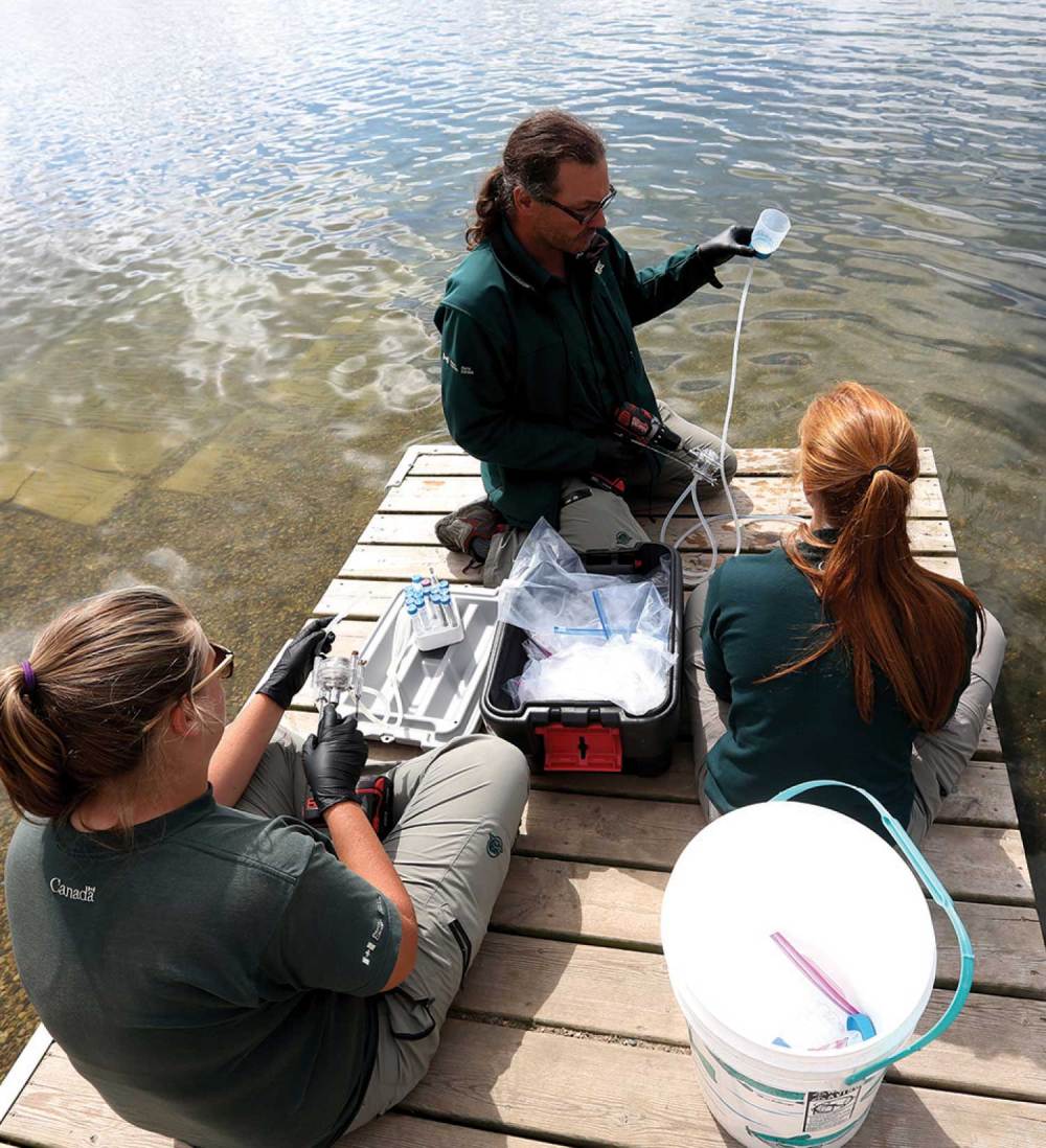 Christian Tremblay of Parks Canada and summer students Colleen Robertson and Kathryn Yarchuk collect water samples at Lake Katherine to test for the presence of zebra mussels.