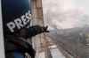 Associated Press photographer Evgeniy Maloletka points at the smoke rising after an airstrike on a maternity hospital, in Mariupol, Ukraine, Wednesday, March 9, 2022. (Mstyslav Chernov / The Associated Press)
