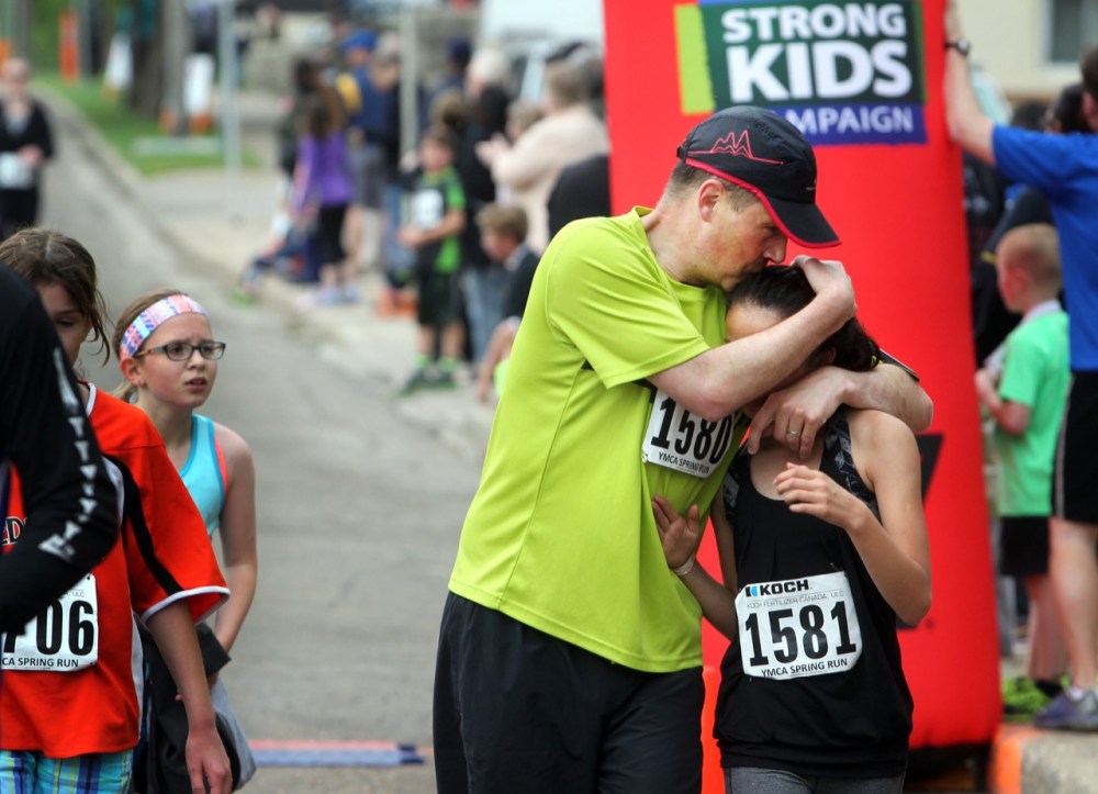 Colin Corneau / Brandon Sun
Greg Peterson hugs daughter Shengli after they finished the five-kilometre run during the 37th annual Koch-YMCA Spring Run on Sunday morning.