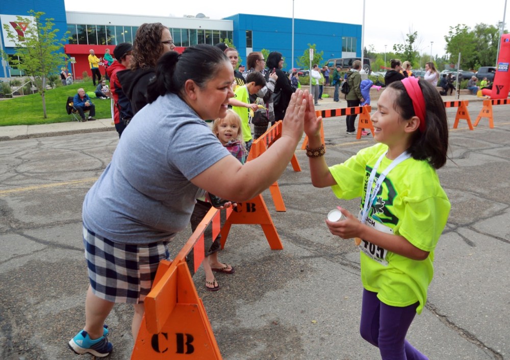 Colin Corneau / Brandon Sun
Maria Alvarado gets a high five after running five kilometres rom her mother Bianca Garcia during the 37th annual YMCA Koch-Spring Run on Sunday morning.