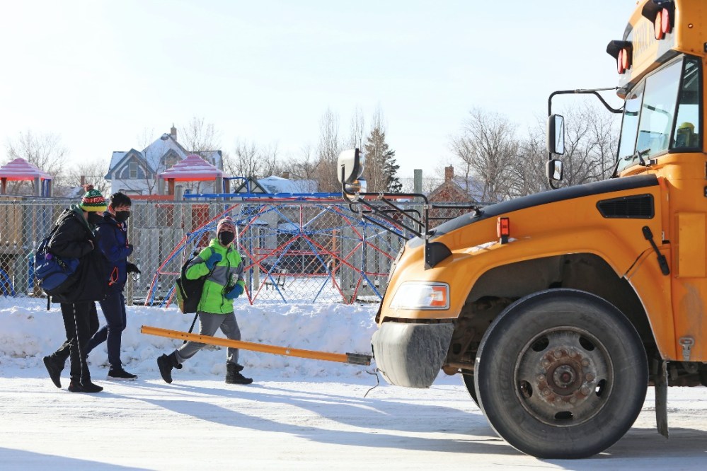 File
Students approach idling buses outside of school.