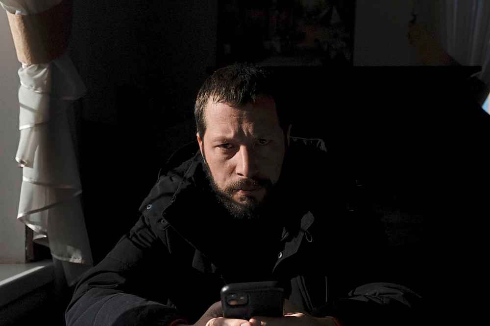 Associated Press videographer Mstyslav Chernov reads news on his phone three days before the start of Russian invasion in Volnovakha, Ukraine, Monday, Feb. 21, 2022. On the evening of Feb. 23, Chernov headed to Mariupol with colleague Evgeniy Maloletka. (Mstyslav Chernov / The Associated Press)