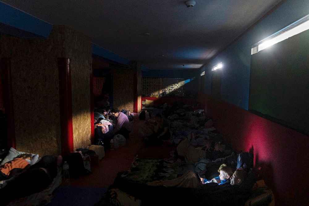 People prepare for the night in the improvised bomb shelter in a sports center, in Mariupol, Ukraine, late Sunday, Feb. 27, 2022. (Mstyslav Chernov / The Associated Press)
