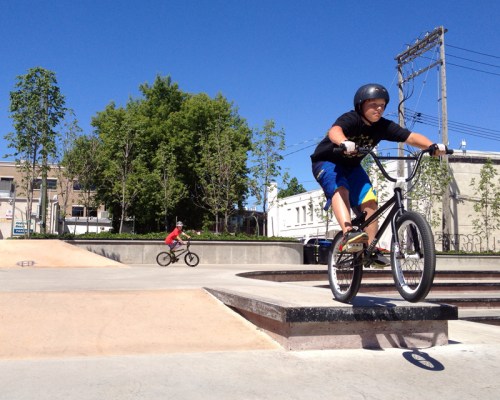 Grant Hamilton / Brandon Sun
Zack Hodgsen, 10, takes a jump on his BMX bike at the Kristopher
Campbell Memorial Skate Plaza on Friday afternoon, as his friend Zach Gwyer, 12, circles around to take a turn behind. The skateboard
park was designed right from its first designs to echo the Prince
Edward Hotel.