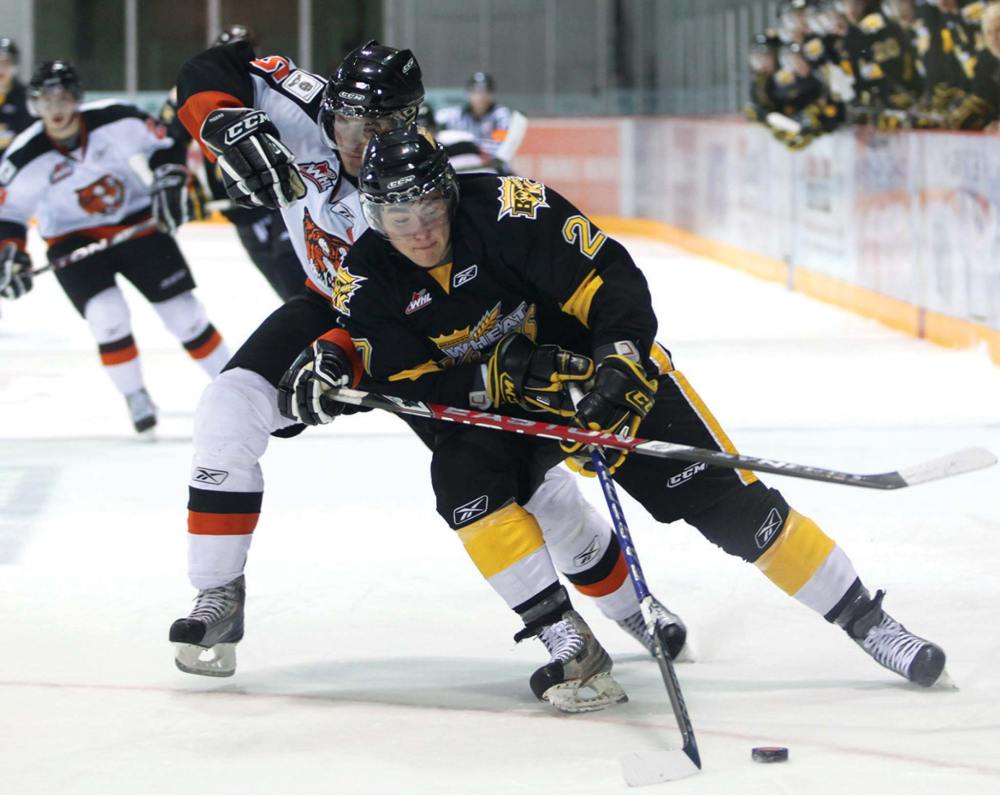 Tim Smith / Brandon Sun
Michael Ferland #27 of the Brandon Wheat Kings tries to work the puck around Thomas Carr #5 of the Medicine Hat Tigers during the first period of WHL action at Westman Place in Brandon, in 2007.