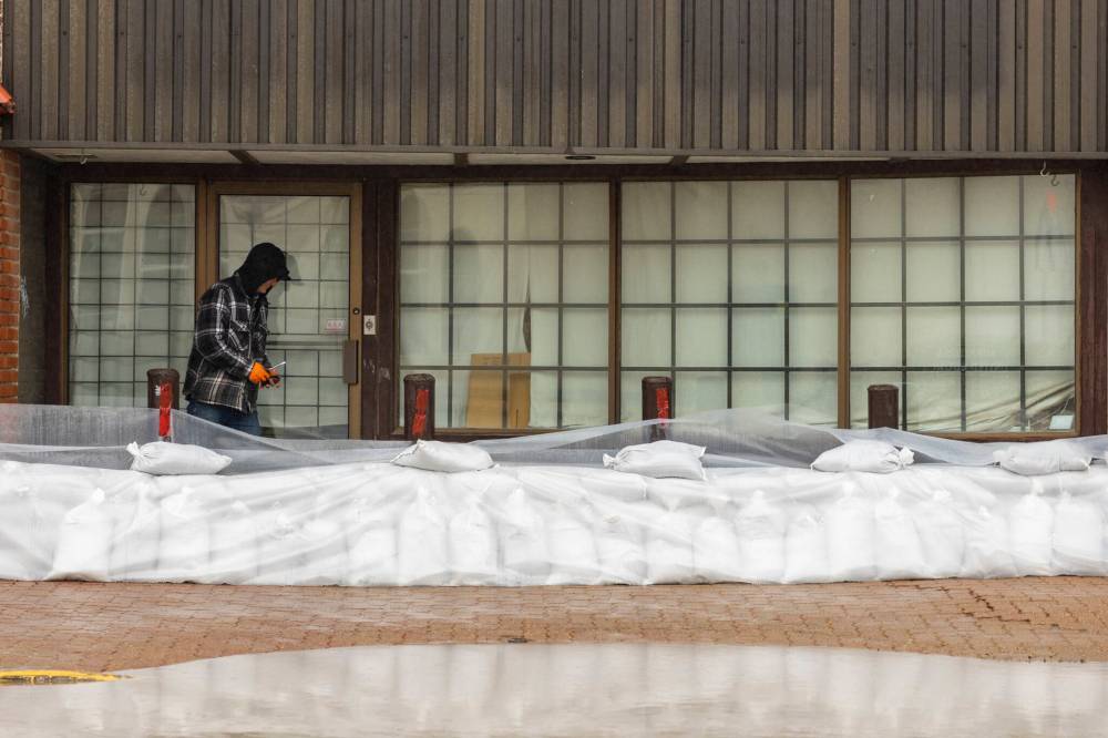Chelsea Smith/The Brandon Sun
Mark Wahoski inspects sandbags outside his business in Minnedosa Friday.