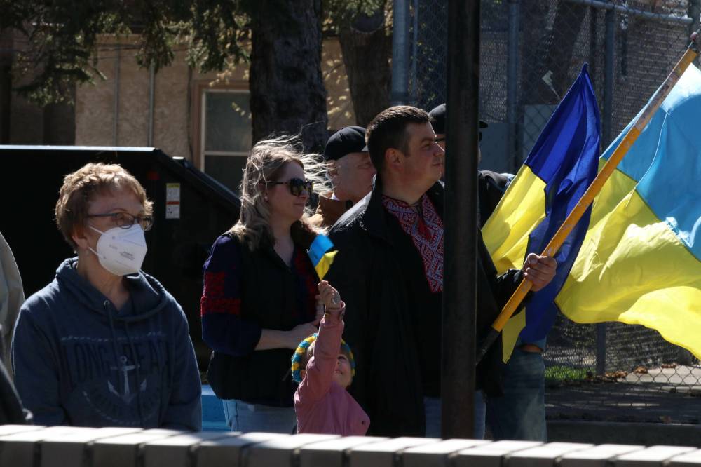 Joseph Bernacki/The Brandon Sun
A child holds up a small Ukrainian flag at Brandon City Hall on Sunday as her parents look onward while listening to the flag ceremony presentation.